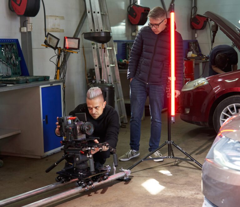 A director watches as a cameraman sets up a professional movie camera before filming on the set. the camera stands on the rails and the operator platform. High quality photo